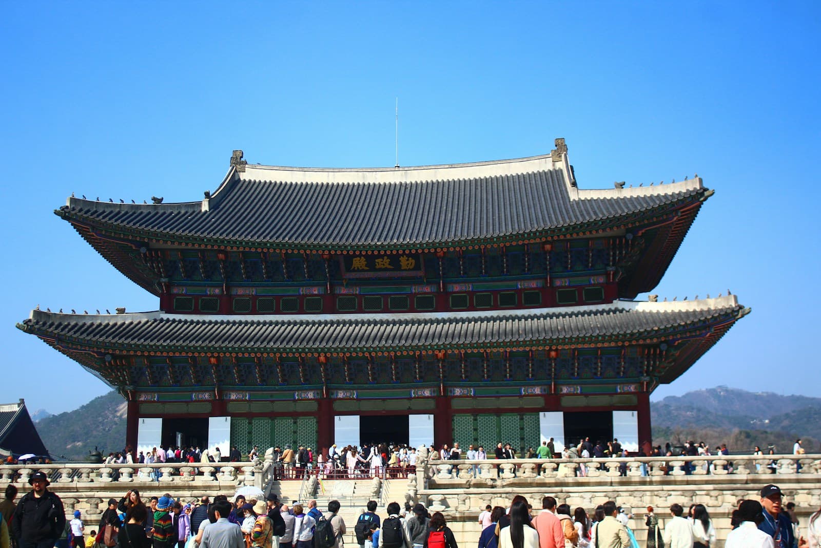 Visitors in front of the traditional architecture of Gyeongbokgung Palace in Seoul, South Korea